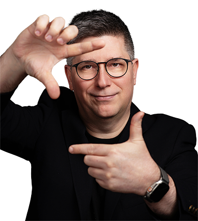 Head and shoulder portrait of Nic Steenhout holding his hands in front of his face, forming a loose frame.